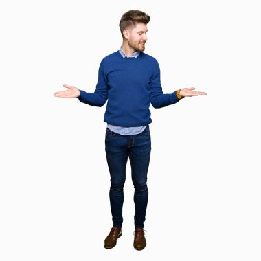 Genç yakışıklı bussines iki elin avuç içi açık gösterilen, sunma ve karşılaştırma ve denge reklam gülen adam