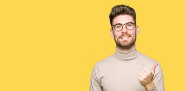 Hareketi el ile mutlu yaşasın yapıyor gözlüklü genç yakışıklı iş adamı. Başarı gösteren kameraya bakarak ifade onaylama.