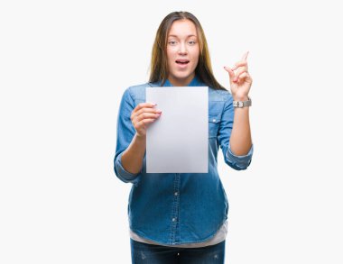 Genç kafkas kadın holding boş kağıt sayfası üzerinde arka plan ile bir fikir ya da gülen yüz, bir numara ile parmak işaret soru sürpriz izole