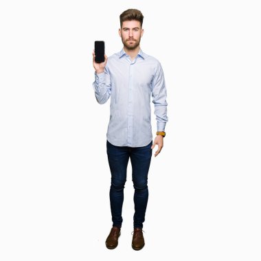 Genç yakışıklı iş gösteren smartphone ekran akıllı yüzünde ciddi düşünme emin bir ifade ile adam