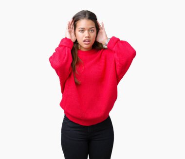 Her iki kulak jest, dedikodu için meraklı ellerde dinliyoruz izole arka plan üzerinde kırmızı kış kazak giyen genç güzel esmer kadın. İşitme sorunu, sağır