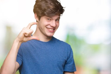 Yakışıklı genç gülümseyen izole arka plan ve süre seyir ve kamera boyutu işaret parmaklarıyla yapıyor el ile kendinden emin eller üzerinde mavi tişört giyiyor. Ölçü kavramı.