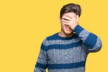 Yakışıklı genç gülümseyen ve gözler için sürpriz kapsayan yüz el ile gülüyor izole arka plan üzerinde. Kör kavramı.