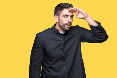 Genç Hıristiyan rahip çok mutlu ve gülümseyen uzakta el ile üzerine kafa seyir izole arka plan üzerinde. Arama kavramı.