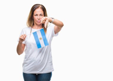 Arjantin bayrağı kızgın yüzü, eksi işareti aşağı antipati başparmak ile gösterilen, ret kavramı ile izole arka plan üzerinde tutan orta yaş İspanyol kadın