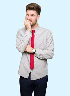 Genç yakışıklı iş adamı stresli ve gergin elle çivi ısırma ağzına bakıyor. Anksiyete sorunu.