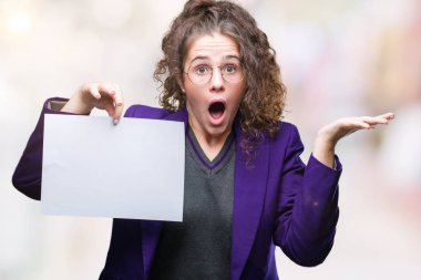 Boş kağıt tutan okul üniforması giyen genç esmer öğrenci kız kocaman bir gülümseme ile çığlık zaferini kutluyor ve ellerini kaldırdı arka plan çok mutlu ve heyecanlı, kazanan ifade izole