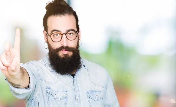 Joven Hipster Hombre Con Pelo Largo Barba Con Gafas Apuntando —  Fotos de Stock