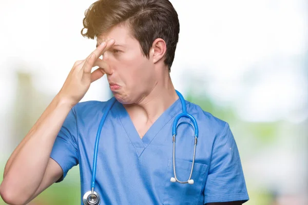 Young Doctor Wearing Medical Uniform Isolated Background Smelling Something Stinky — Stock Photo, Image