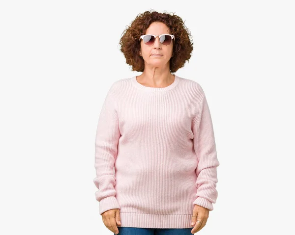 美しい中間エイガーの年配の女性の顔に真剣な表情で孤立した背景リラックスにピンクのセーター サングラスを着てします シンプルで自然なカメラを見てください — ストック写真