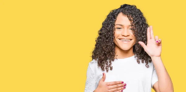 Jovem Mulher Bonita Com Cabelo Encaracolado Vestindo Shirt Branca Jurando — Fotografia de Stock