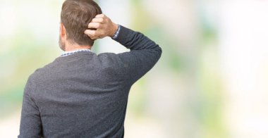 Yakışıklı orta yaş komuta sizde izole arka plan geriye düşünme hakkında şüphe kafasına el ile üzerinden bir kazak giyiyor