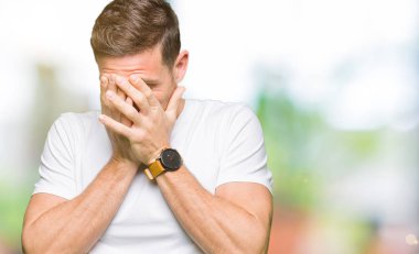 Yakışıklı adam üzgün ifadeyle yüz eller ile ağlayarak süre kapsayan Casual beyaz t-shirt giyiyor. Depresyon kavramı.