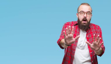 Üzerinde gözlük takan Genç beyaz hipster adam arka plan korkuyor ve korku ifade dur hareketi el ile ile dehşete şokta bağırarak izole. Panik kavramı.