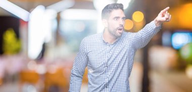 İzole arka plan ile sürpriz devam et, parmakla üzerinden yakışıklı delikanlı ağız açık ifade, önünde bir şey hayret