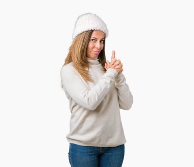 El hareketi ile sembolik silah tutan, çekim silah, kızgın yüz öldürme oynarken arka plan üzerinde kış kazak ve şapka giyen güzel orta yaş kadın izole