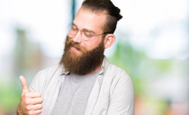 Gurur arayan genç sarışın adam gözlük, gülümseyen iş jest tarafa yaşasın