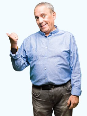 Şık gömlek arıyorsunuz ve başparmak yanında yukarıyı mutlu yüz ile gülümseyen yakışıklı üst düzey businesss adam.