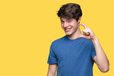 Yakışıklı genç gülümseyen izole arka plan ve süre seyir ve kamera boyutu işaret parmaklarıyla yapıyor el ile kendinden emin eller üzerinde mavi tişört giyiyor. Ölçü kavramı.