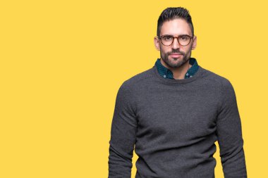 Üzerinde gözlük takan genç yakışıklı adam arka plan gevşek yüzünde ciddi bir ifade ile izole. Basit ve doğal kameraya bakıyor.