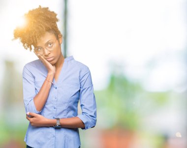 Güzel genç Afro-Amerikan iş kadını izole arka plan düşünme seyir üzerinde yorgun ve sıkılmış çapraz silah depresyon sorunları ile.