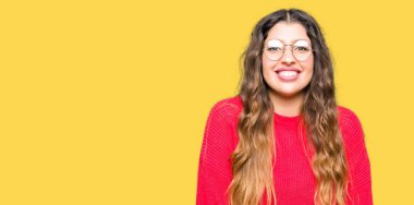 Yüzünde mutlu ve güzel bir gülümseme ile kırmızı gözlük takan genç güzel kadın. Şanslı kişi.