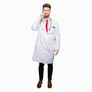 Tıbbi kat ağız ve dudaklar giyen genç yakışıklı Doktor adam olarak ZIP parmak ile kapatın. Gizli ve sessiz, tabu söz