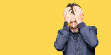 Çünkü umutsuz ve stresli baş ağrısı acı bir ceket giyen orta yaş yakışıklı adam ağrı ve migren. Ellerini kafasına.