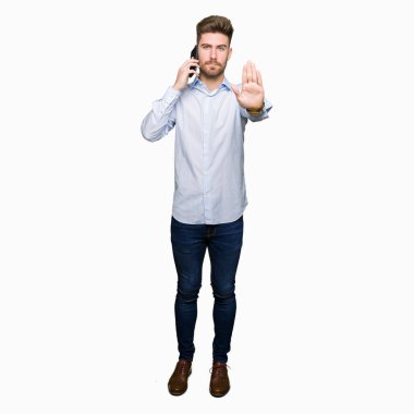 Genç yakışıklı adam iş smartphone üzerinde açık eliyle dur işareti ile ciddi ve kendine güvenen ifade, savunma jest yapıyor konuşuyor