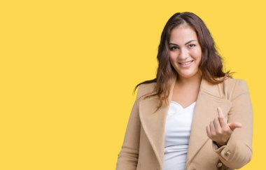 Artı boyutu genç kadın giyiyor kış ceket izole arka plan üzerinde güzel Beckoning gel burada mutlu ve gülümseyerek el davet ile jest