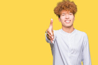 Tebrik ve konuksever dost sunan karşılıklı gülümseyen şık gömlek giymiş afro saçlı Genç yakışıklı iş adamı. Başarılı iş.