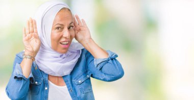 Her ikisi de dinliyoruz izole arka plan üzerinde Arap hijab giyen orta yaş Doğu Arap kadın kulak jest, dedikodu için meraklı eller. İşitme sorunu, sağır