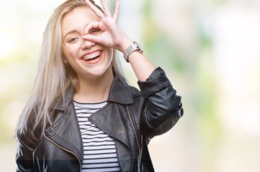 Gülümseyerek el parmakları ile mutlu yüz üzerinden seyir göz ile ok jest yapıyor izole arka plan üzerinde moda ceket giyen genç sarışın kadın.