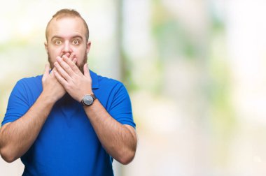 Üzerinde mavi gömlek giymiş genç beyaz hipster adam arka plan ağız hata için elleriyle kapsayan şok izole. Gizli kavramı.