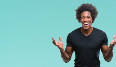 Afro Amerikalı adam deli kutluyor ve silah ile başarı için heyecanlı çığlık kaldırdı ve açık gözleri hayret izole arka plan üzerinde. Kazanan kavramı