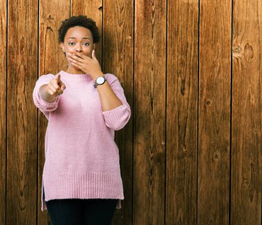 Güzel genç Afro-Amerikan kadın yüzünden izole arka plan sizin parmak el kamerasıyla ağzına, utanç ifadesi işaret eden gülme