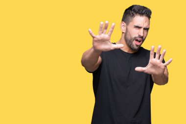 Genç yakışıklı adam şokta bağırarak korkuyor ve dehşet korku ifade dur hareketi el ile ile izole arka plan üzerinde. Panik kavramı.