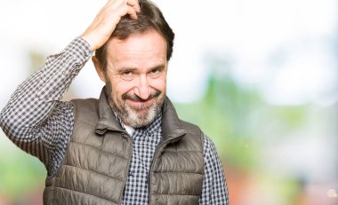 Orta yaş yakışıklı adam giyen kış yelek yanıltır ve soru hakkında merak ediyorum. Şüphe, kafasına el ile düşünme ile belirsiz. Dalgın kavramı.