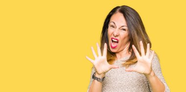 Moda kazak korkuyor ve korku ifade dur hareketi el ile ile dehşete giyen güzel orta yaş kadın şok bağırarak. Panik kavramı.