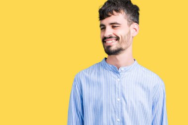 Genç yakışıklı iş adamı izole arka plan uzak tarafına gülümseme ile yüzünde, doğal ifade seyir üzerinde. Kendine güvenen gülüyor.