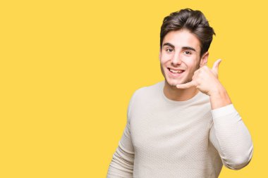 Yakışıklı delikanlı yapıyor gülümseyen izole arka plan üzerinde telefon hareketi ile el ve parmak telefonda konuşuyor gibi. Kavramları iletişim.