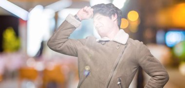 Üzerinde kış ceket giyen genç yakışıklı adam arka plan geri uzanan izole, yorgun ve rahat, Uykulu ve erken sabah esneme