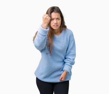 Öfkeli ve sinirli sinirli ve öfke ile bağırarak süre öfkeli yumruk yükselterek izole arka plan üzerinde mavi kış kazak giyen genç güzel esmer kadın. Öfke ve agresif kavramı.