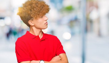 Afro saç giyen ile yakışıklı delikanlı kırmızı t-shirt gülümseyen yan kolları olan isteyen ikna ve kendine güvenen geçti