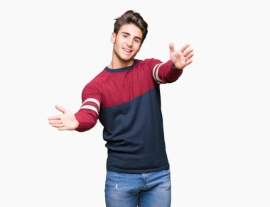 Yakışıklı delikanlı sarılmak için kollarını açarak gülümseyerek kameraya bakarak izole arka plan üzerinde. Neşeli ifade kucaklayan mutluluk.
