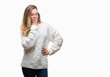 Kış kazak ve güneş gözlüğü izole arka plan üzerinde giyen genç güzel sarışın kadın el ağzıyla kapsayan yorgun esneme sıkılmış. Restless ve uyku hali.