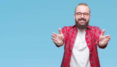Sarılmak için kollarını açarak gülümseyerek kameraya bakarak izole arka plan üzerinde gözlük takan Genç beyaz hipster adam. Neşeli ifade kucaklayan mutluluk.