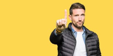 Yakışıklı adam giyen kış ceket işaret parmağını ve kızgın ifade ile