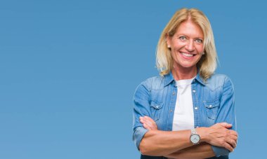 Orta yaş sarışın kadın izole arka plan mutlu yüz çapraz silah kameraya bakarak ile gülümseyen yüzünden. Olumlu bir kişi.