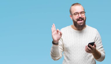 Genç beyaz hipster adam texting parmak, mükemmel sembolü ile ok işareti yapıyor izole arka plan üzerinde Smartphone kullanarak ileti gönderme
